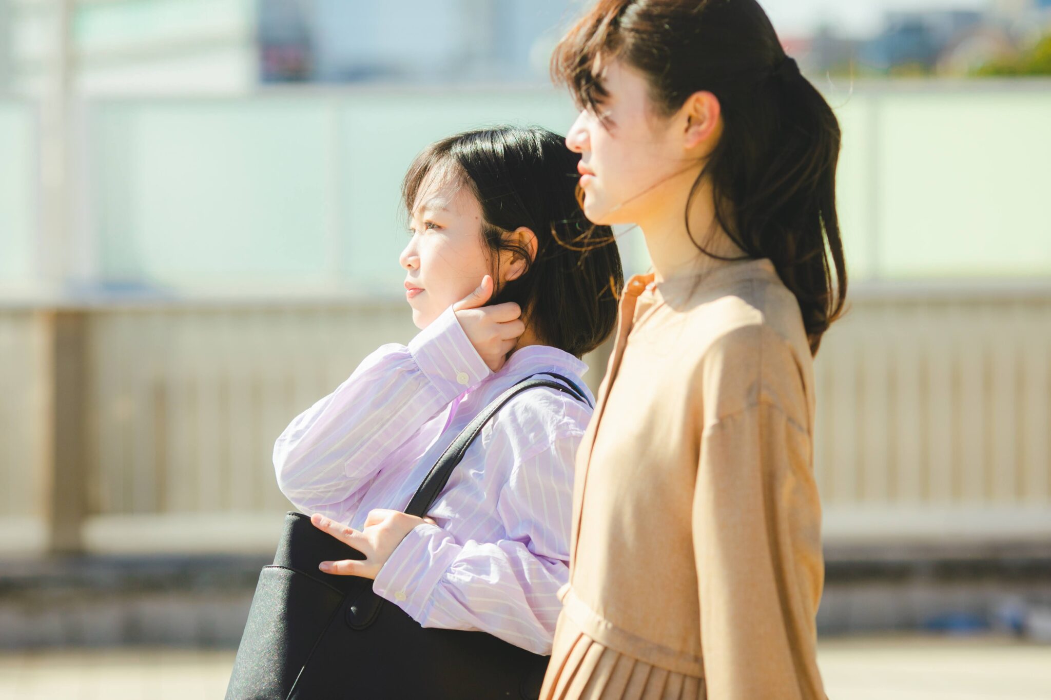 屋外で会話をしながら歩く二人の女性