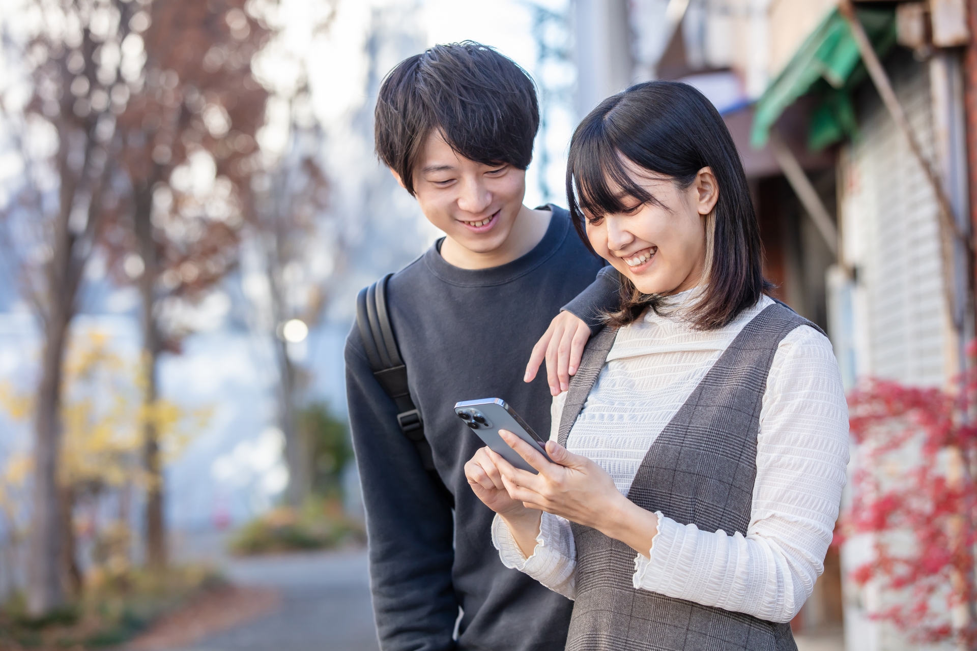 スマホを見て笑顔を見せる男女