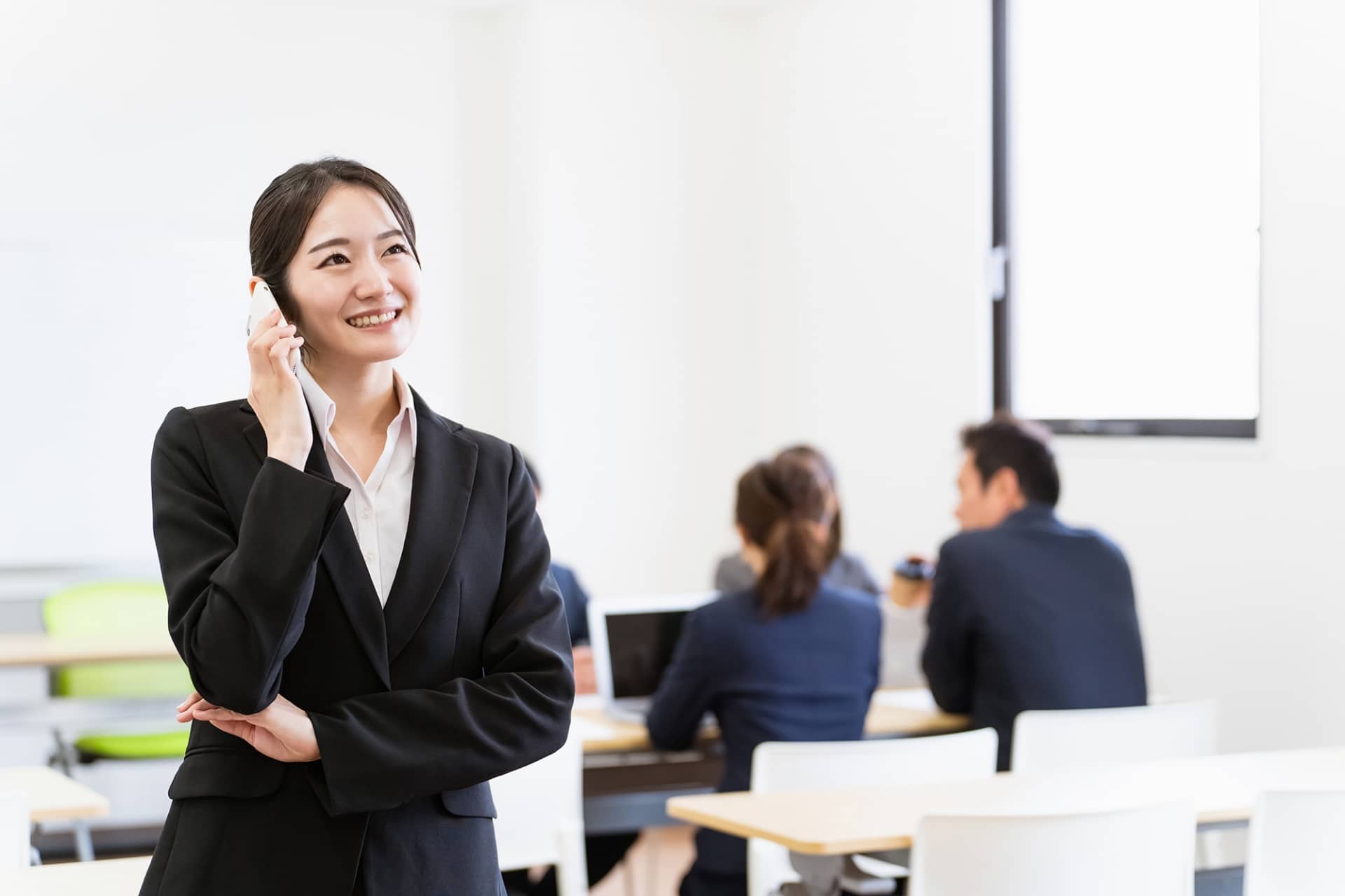 電話をかけるスーツ姿の女性