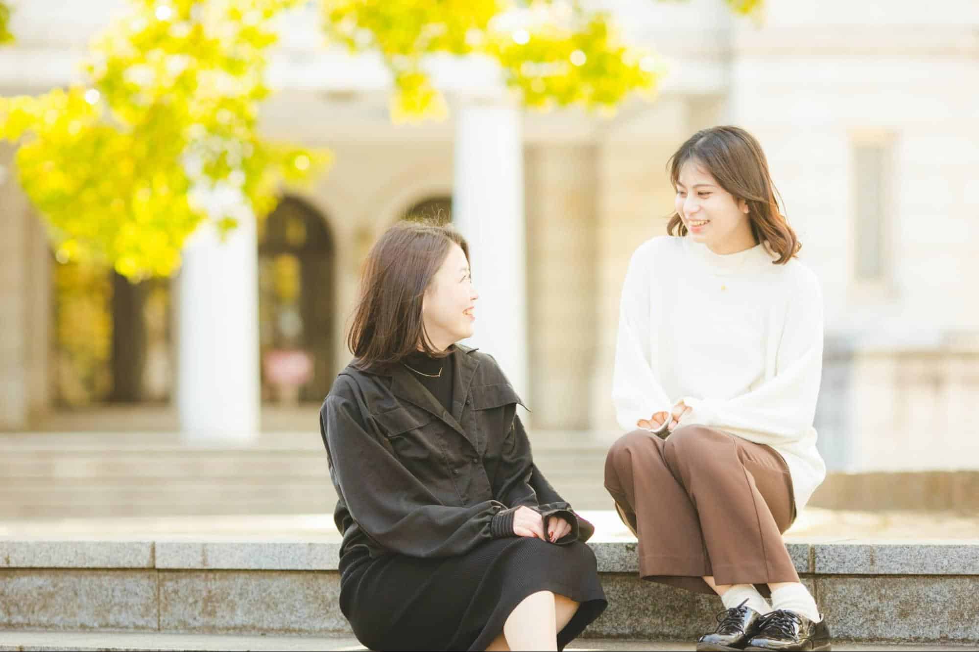 屋外で談笑する2名の女性