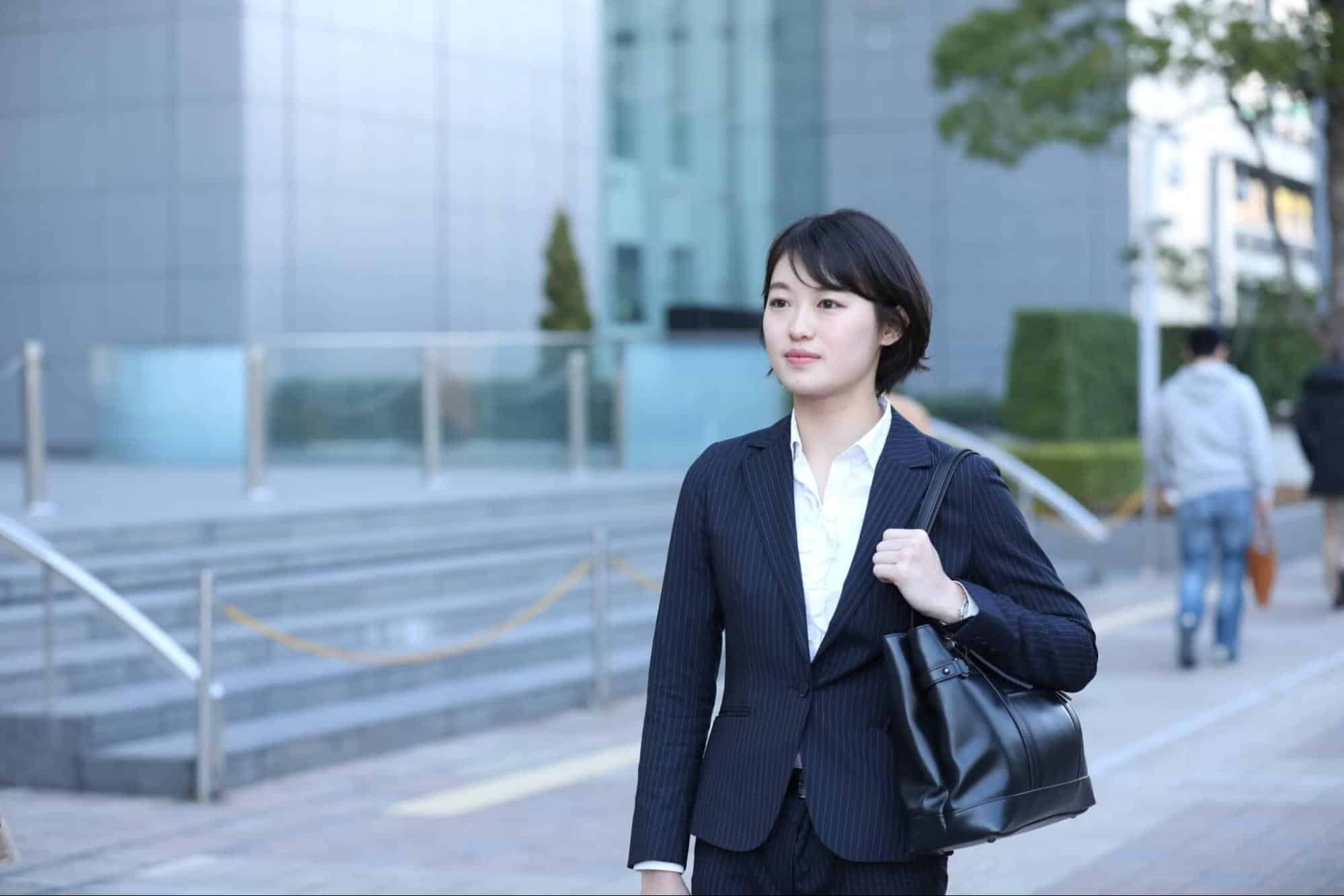 オフィスビル街を歩くスーツ姿の女性