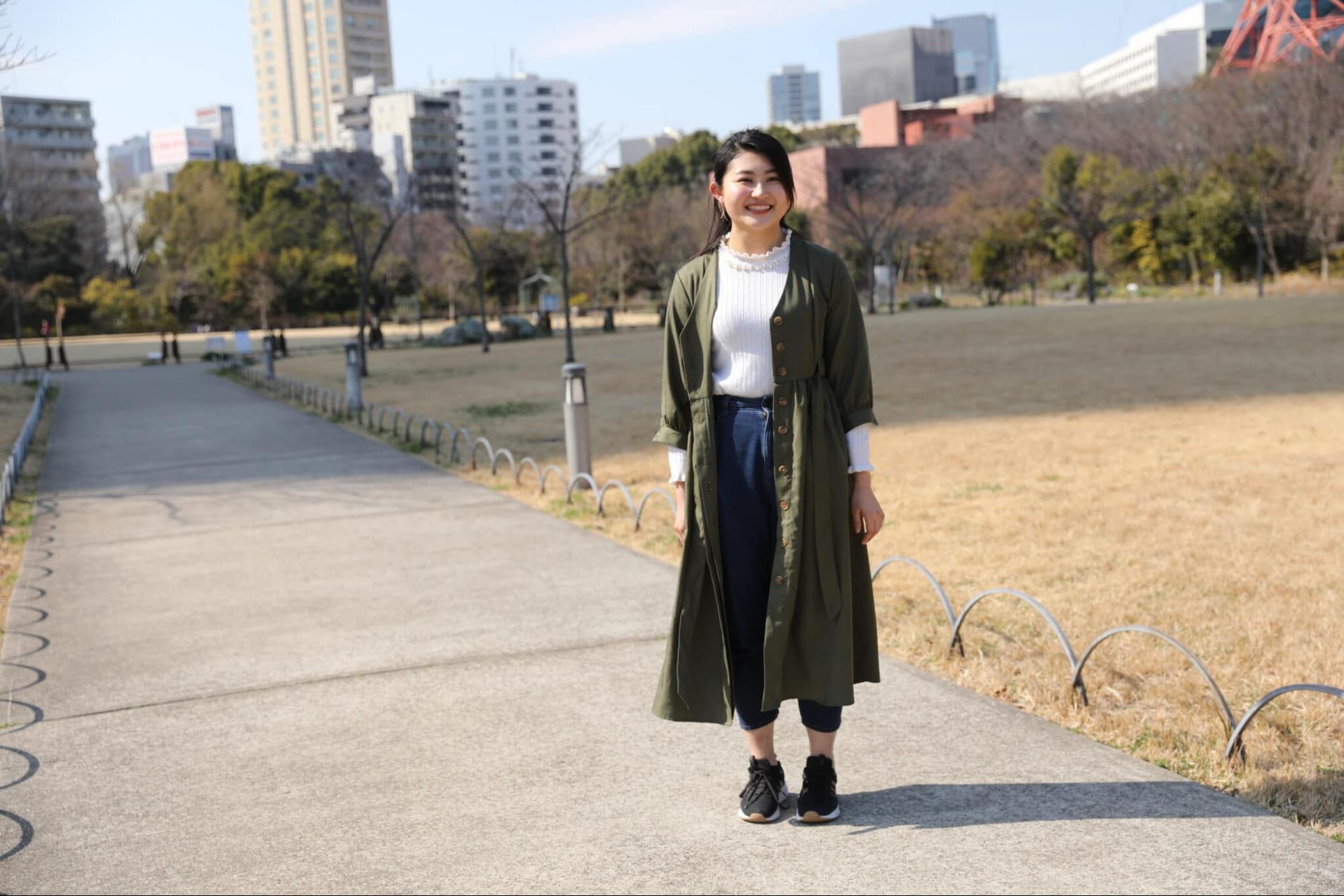 立っている笑顔の女性 芝生の背景