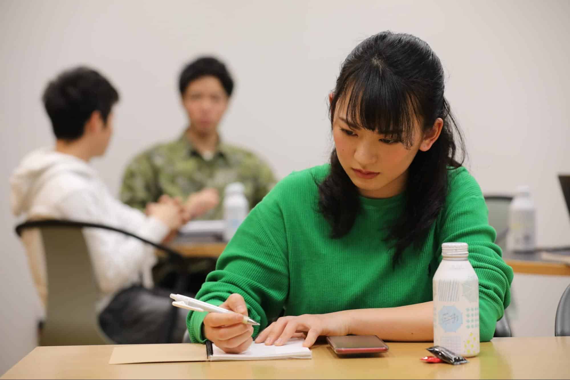 机に向かって勉強をする女性