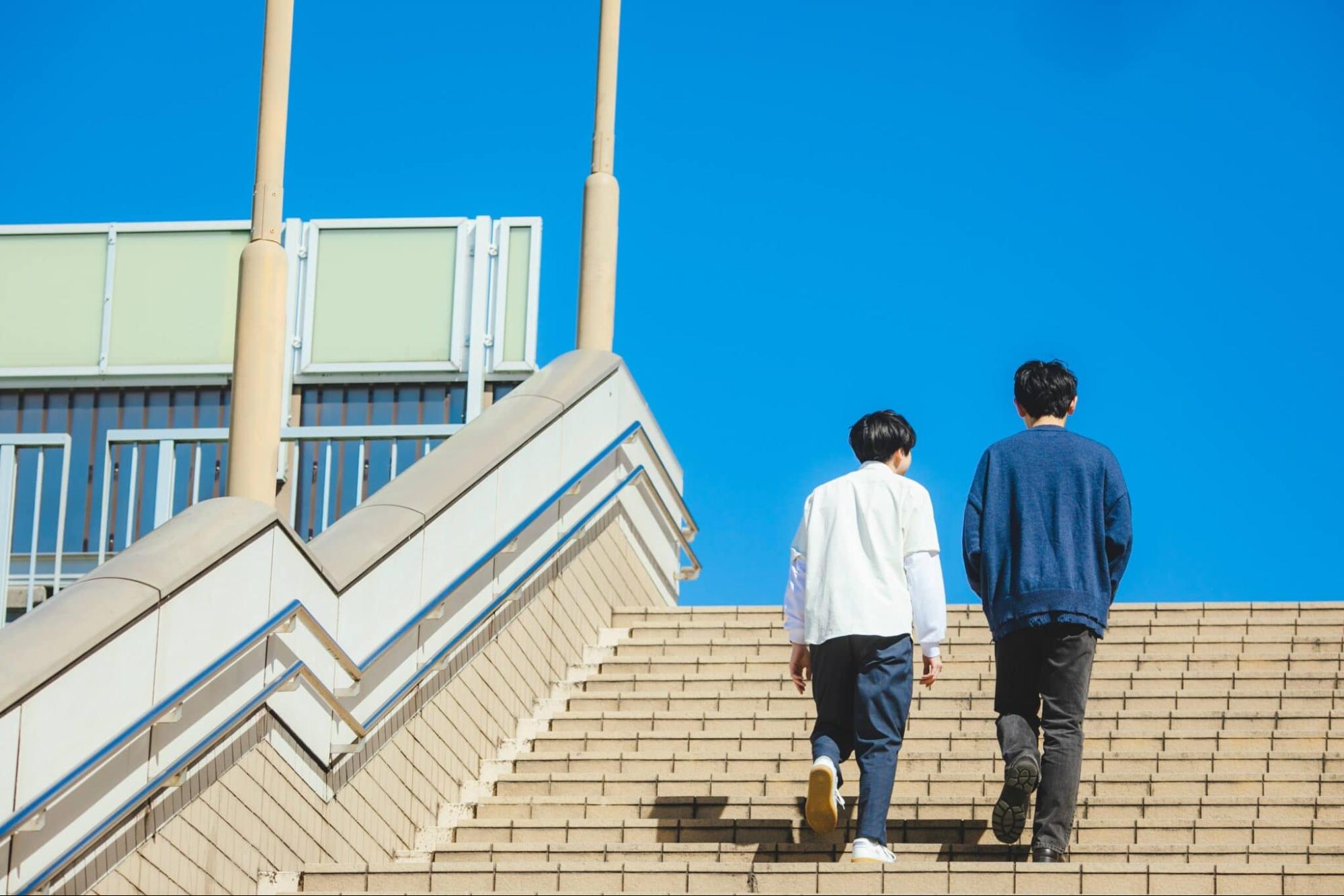 階段を上る2人の男性 後ろ姿