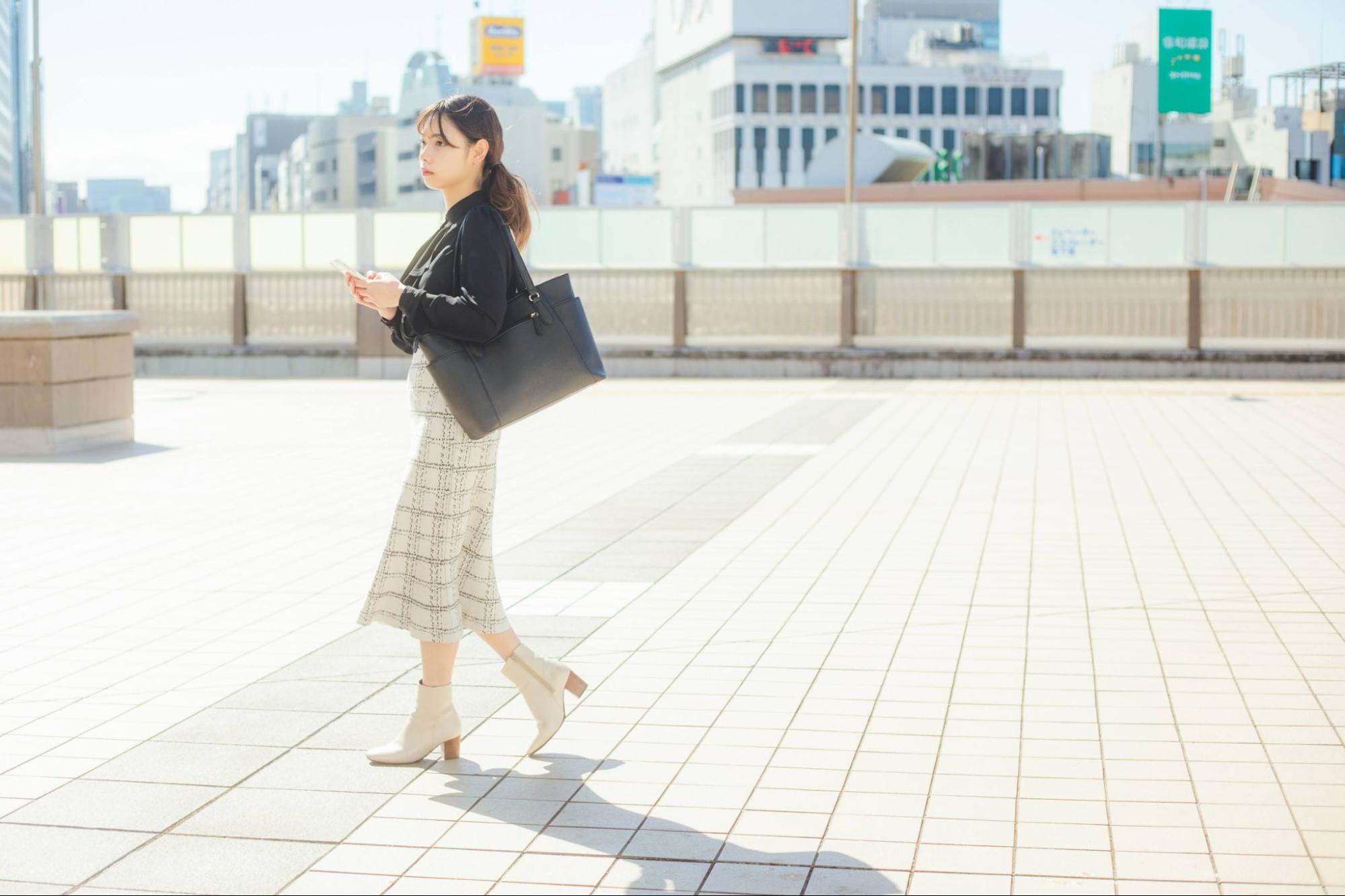 スマホを持って歩いている女性 就活生イメージ