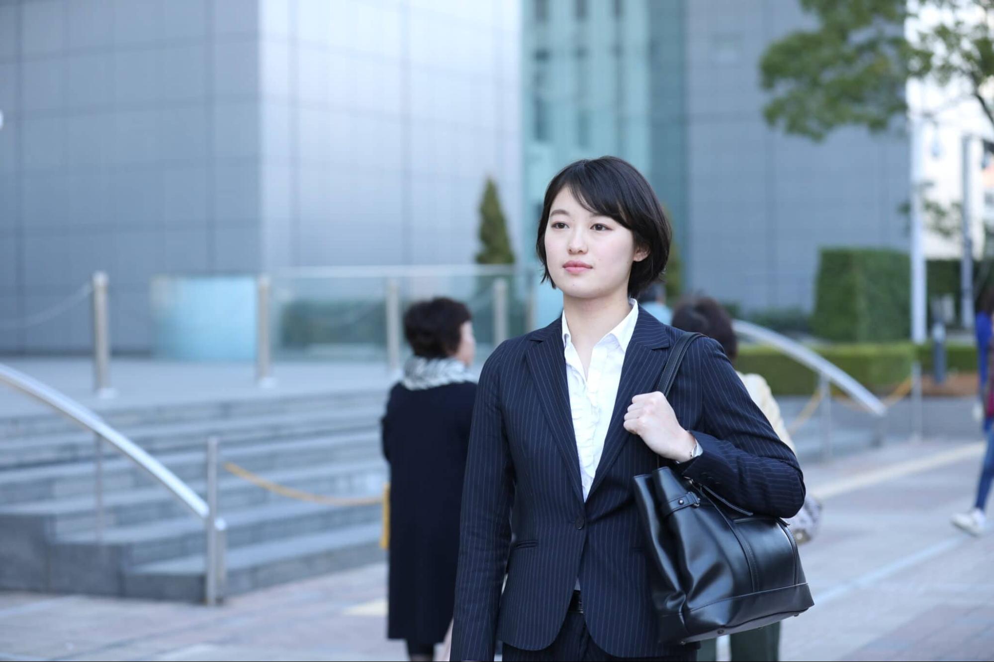 リクルートスーツ姿で歩く就活生 女性