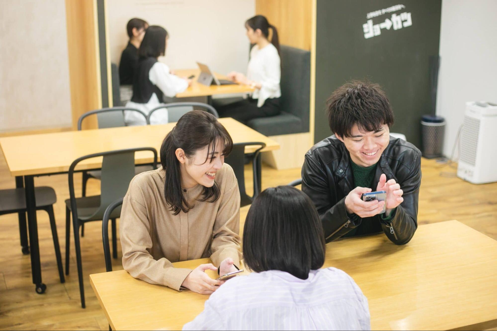 スマホを見て談笑する3人の就活生