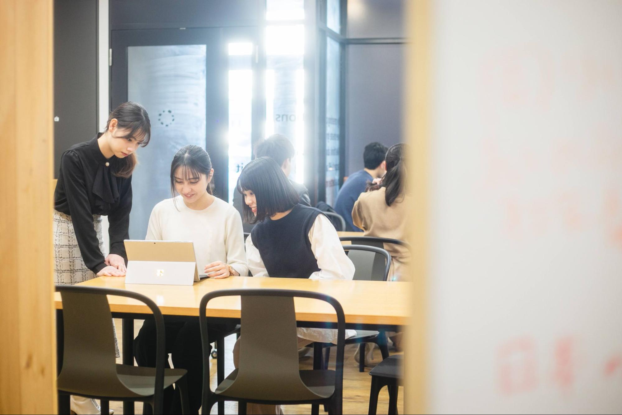 PCを見る3人の就活生 女性