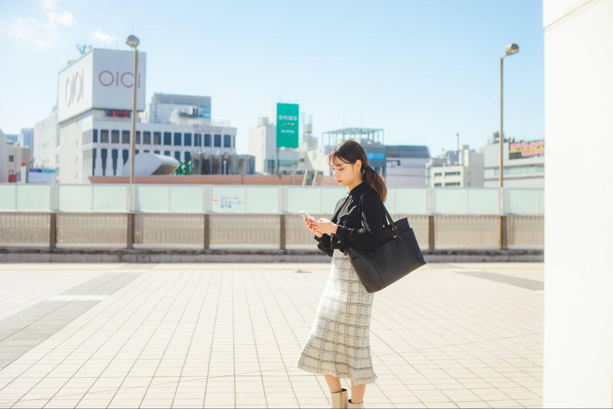 スマホを見る女性 丸井百貨店の背景