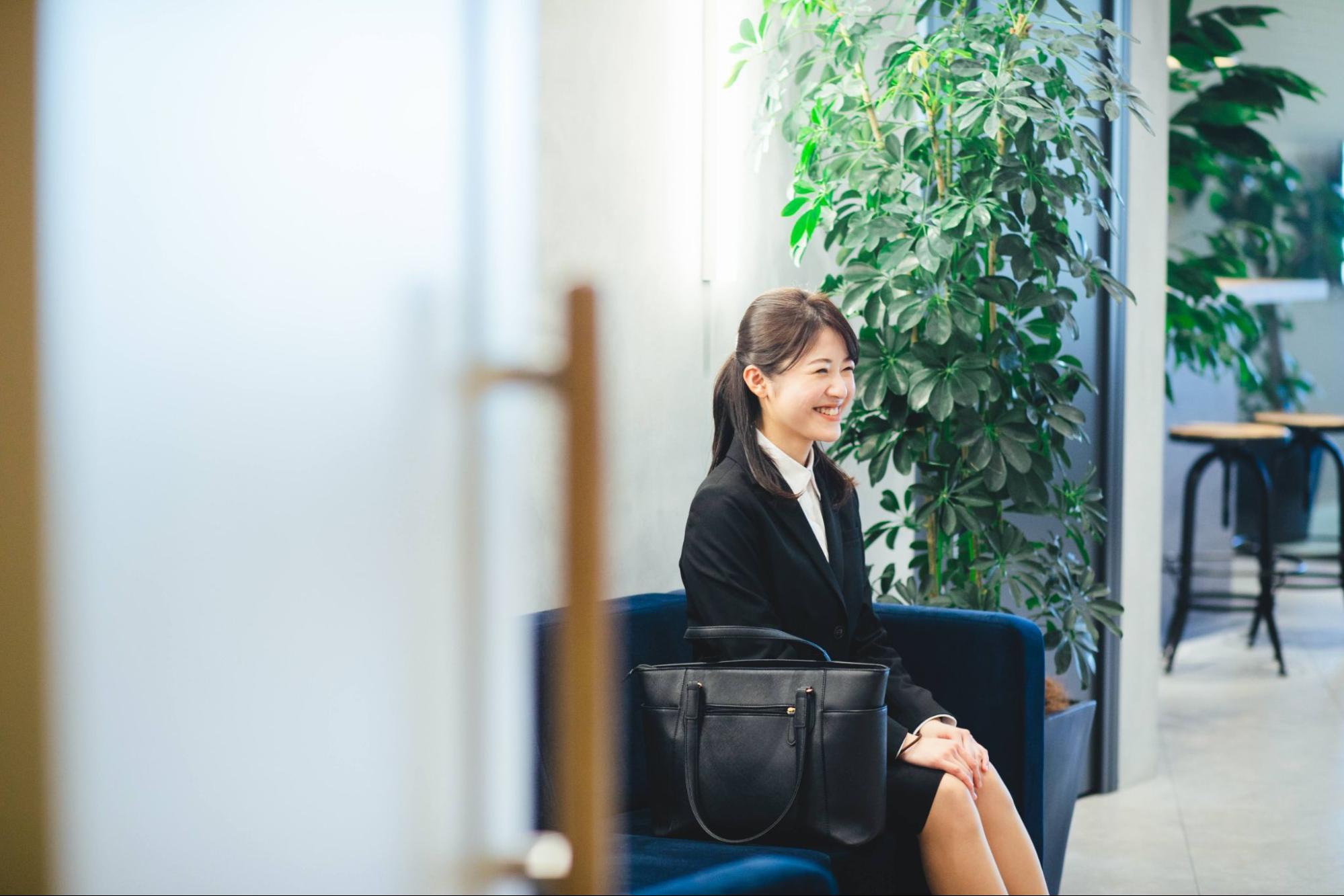 椅子に座る笑顔の就活生 女性