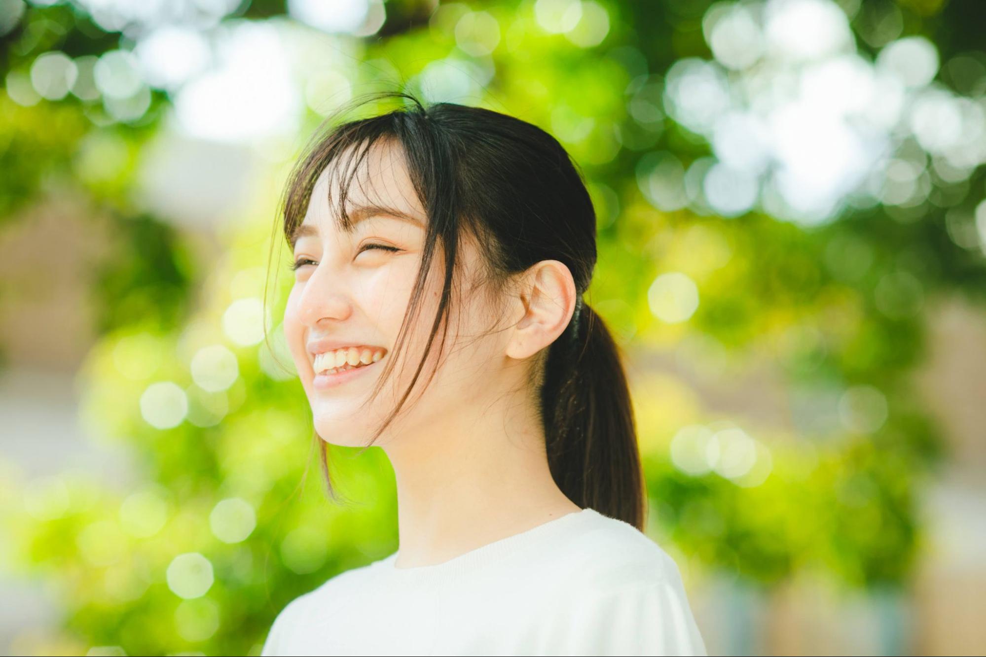 笑顔の女性 新緑の背景 就活生イメージ