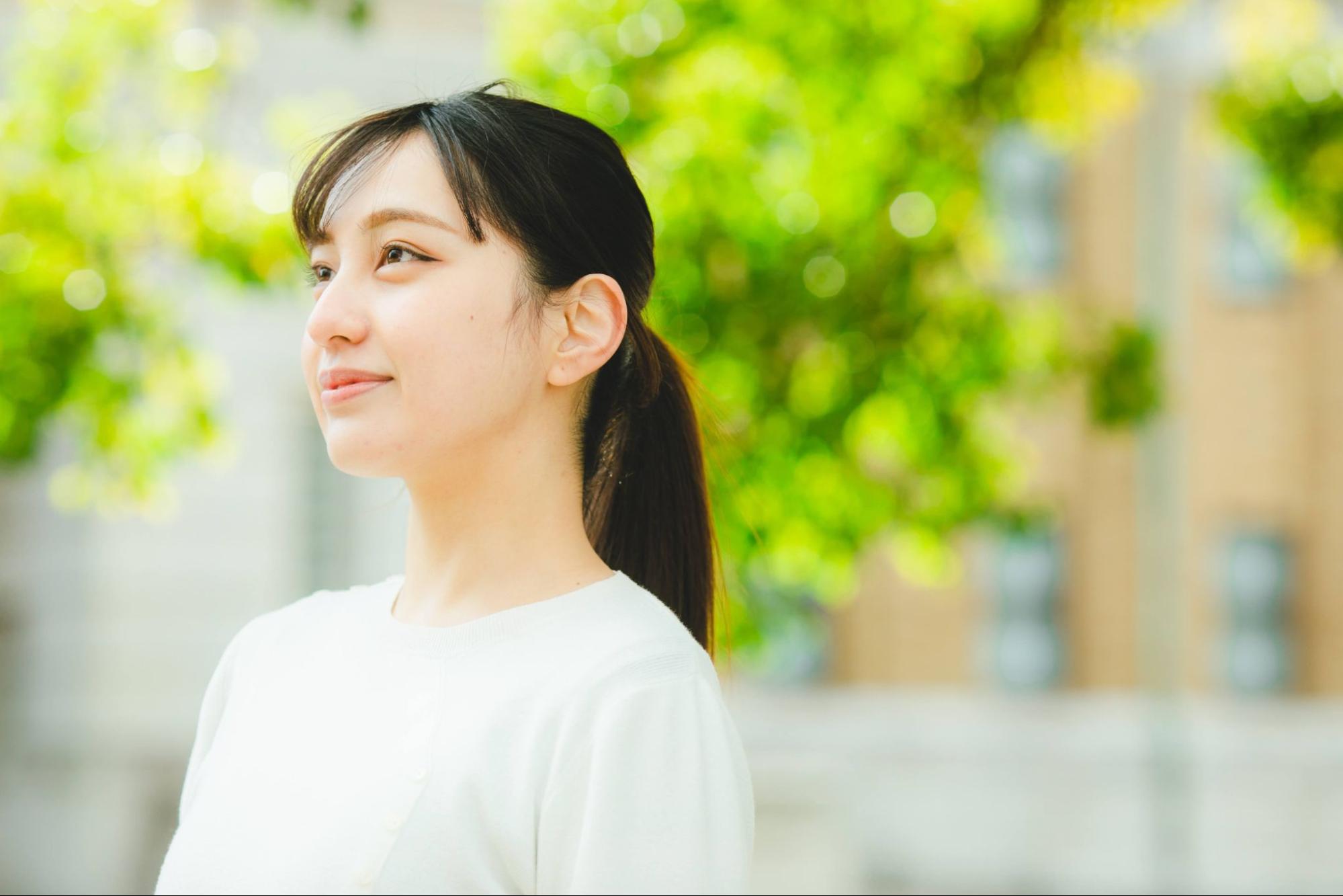 微笑む就活生 女性 新緑の背景