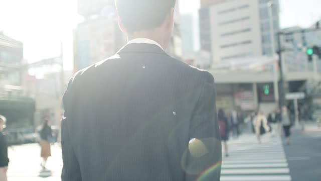 横断歩道を渡る男性の後ろ姿